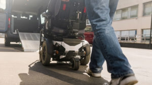 Closeup of wheelchair being pushed into a wheelchair adapted van.