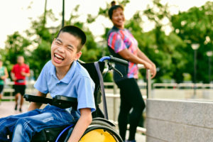 Happy child in wheelchair playing outside