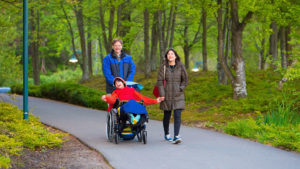 Child in wheelchair happy outside with family in park