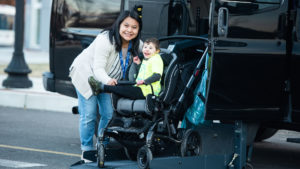 Special child in wheelchair posing for camera outside his wheelchair van