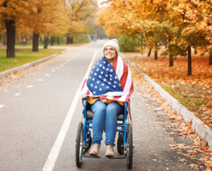 Woman in wheelchair wrapped in the American Flag.
